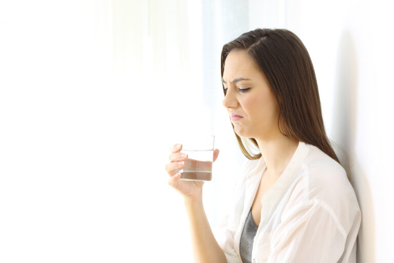 Woman smelling glass of water