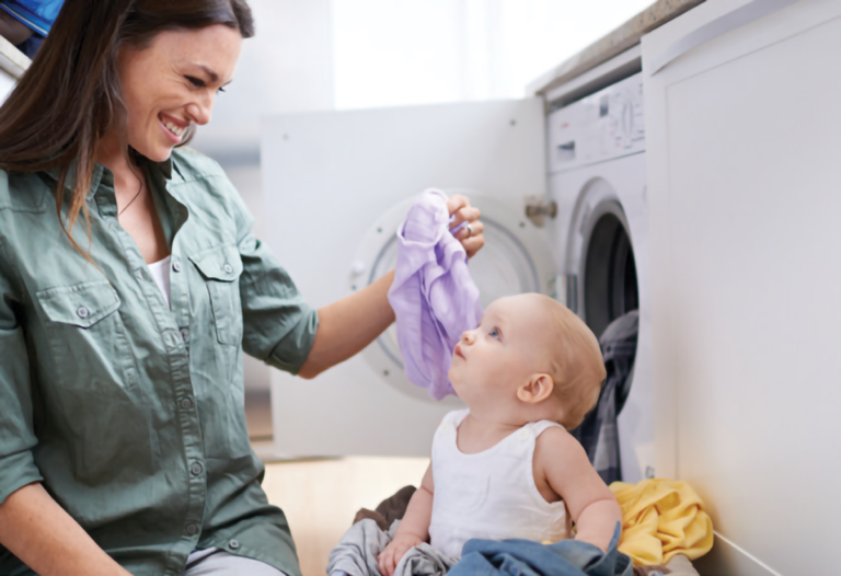 Mom washing laundry with baby